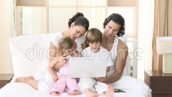 家人在床上用笔记本电脑视频的预览图
