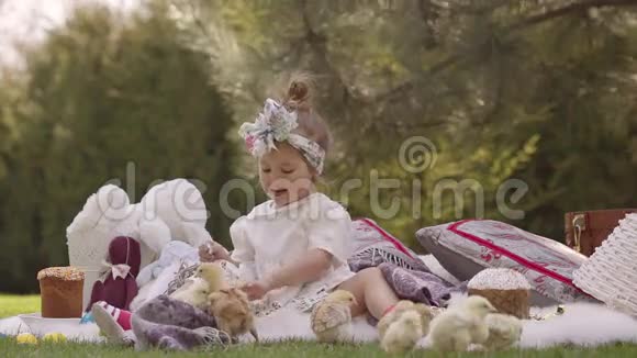 快乐的孩子坐在复活节装饰的草地上视频的预览图