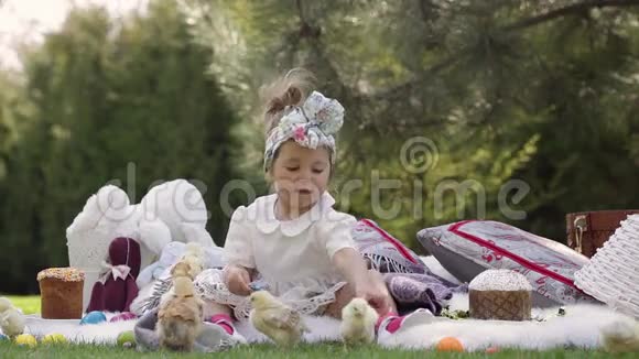 快乐的孩子坐在复活节装饰的草地上视频的预览图