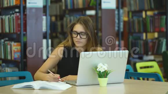 在图书馆电脑工作的女学生视频的预览图