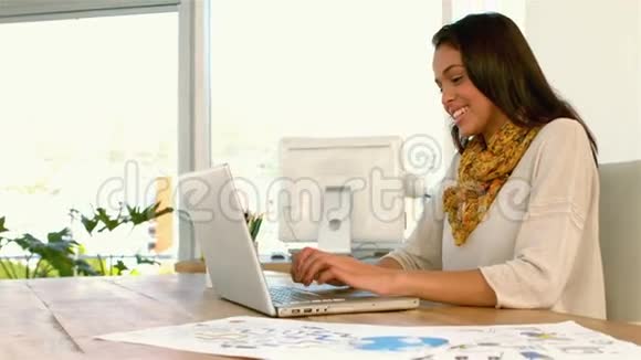漂亮女孩在桌子上用笔记本电脑视频的预览图