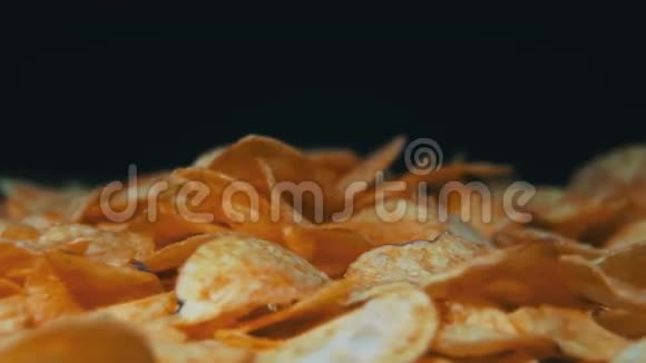 马铃薯芯片在黑色背景下旋转视频的预览图