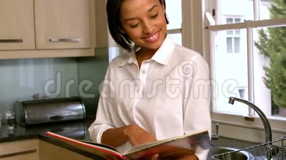 在厨房看书的漂亮女人视频的预览图