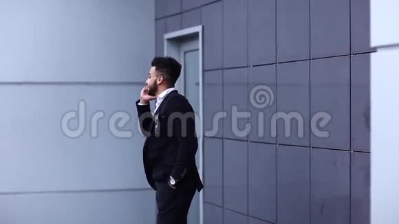 英俊的阿拉伯男子在商务中心用手机交谈视频的预览图
