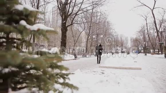 美丽的年轻女子在冬季公园里视频的预览图