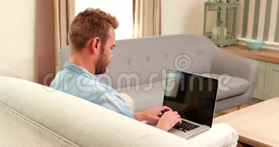 沙发上的帅哥用笔记本电脑视频的预览图