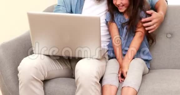 快乐的父亲和女儿使用笔记本电脑视频的预览图