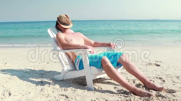 在海滩的躺椅上放松的人视频的预览图