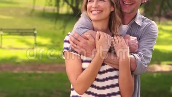 微笑的情侣拥抱在公园里视频的预览图