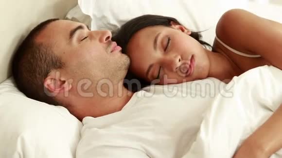 快乐的一对夫妻睡在床上视频的预览图