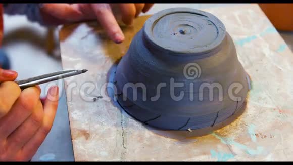 艺术家在陶器碗上作画的手视频的预览图