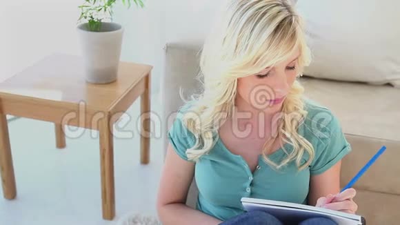 年轻的金发女人在写作视频的预览图