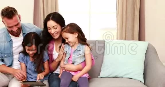 幸福的家庭在沙发上用平板电脑视频的预览图
