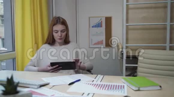 坐在办公室里拿着平板电脑的女人视频的预览图