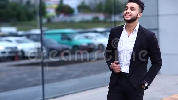 商务中心的阿拉伯男孩站在那里微笑着看着手表视频的预览图