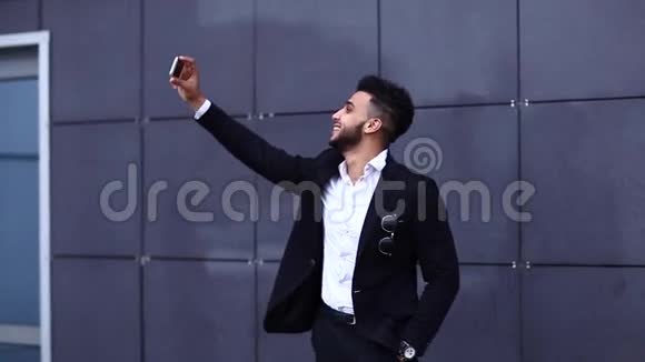 英俊的阿拉伯男人在商务中心自拍智能手机视频的预览图