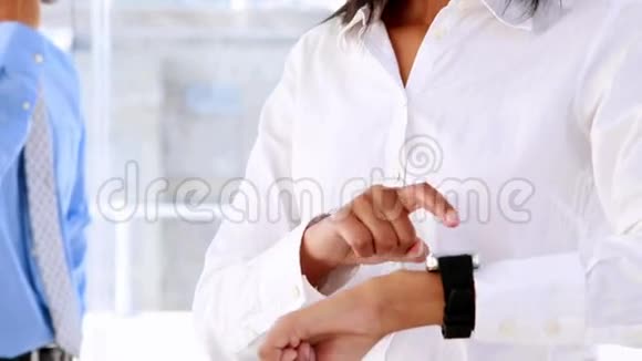 女商人微笑着用智能手表视频的预览图
