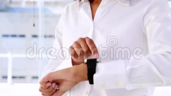 女商人微笑着用智能手表视频的预览图