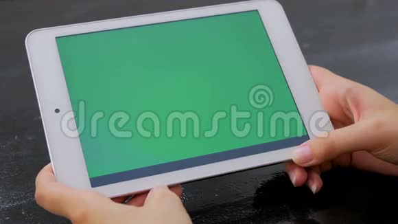 女人看着绿色屏幕的平板电脑视频的预览图