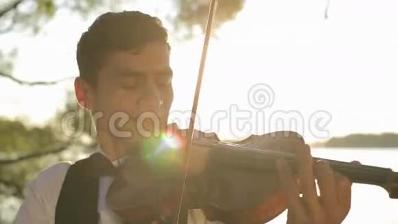 小提琴手在日落时拉小提琴视频的预览图