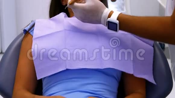 牙医用工具检查女性病人视频的预览图