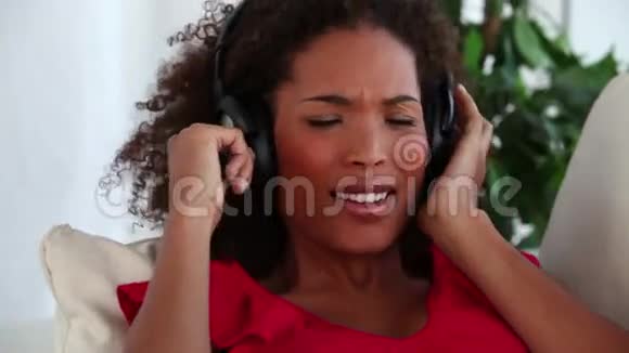 女人一边唱歌一边听音乐视频的预览图