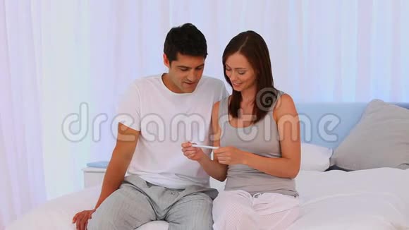 一对夫妇在看一个阳性的妊娠检查视频的预览图