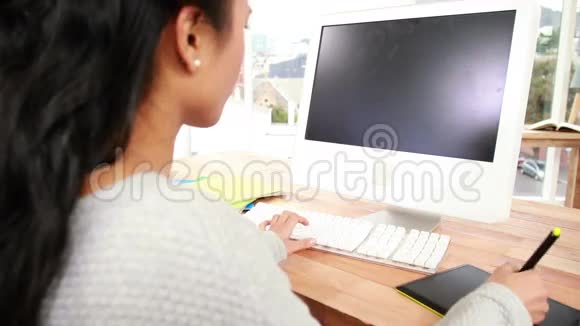 休闲亚洲设计师在办公桌工作视频的预览图