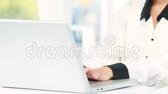 亚洲女商人用她的笔记本电脑视频的预览图