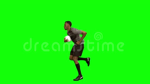 严肃的橄榄球运动员带着球跑视频的预览图