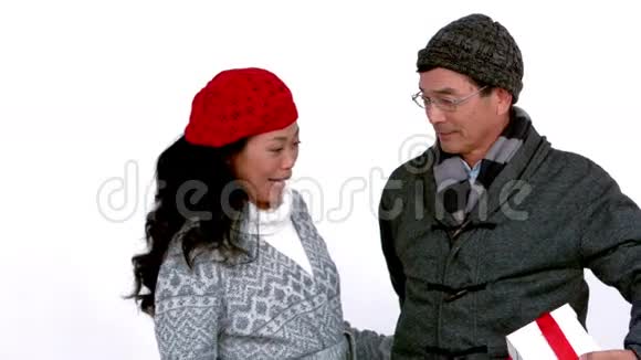 一对穿暖和衣服的夫妇拿着礼物视频的预览图