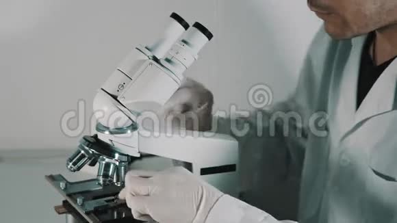 年轻医生透过显微镜看视频的预览图