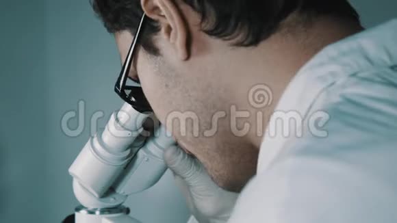 年轻医生透过显微镜看视频的预览图