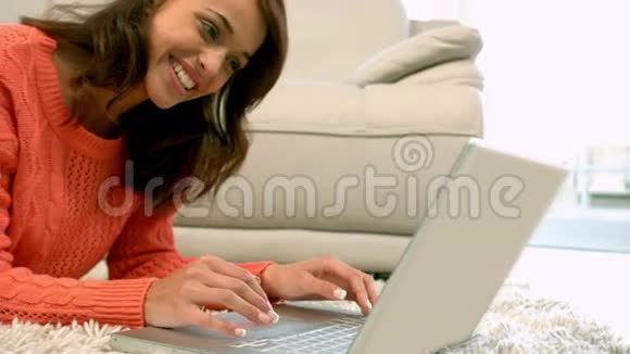 在客厅地板上用笔记本电脑的女人视频的预览图