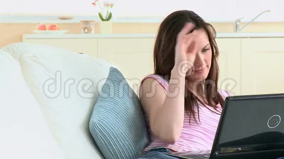 女人在家工作手提电脑躺在沙发上视频的预览图