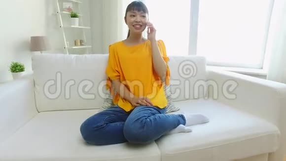 快乐的亚洲女人在家打智能手机视频的预览图