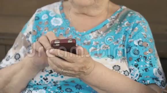 年老的女人拿着手机视频的预览图
