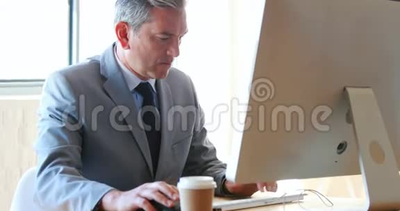 商人用他的电脑和智能手机视频的预览图