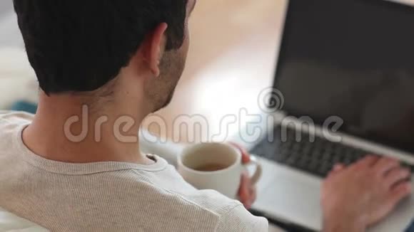 男人一边喝咖啡一边用笔记本电脑视频的预览图