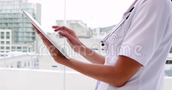 护士在外衣使用平板电脑视频的预览图