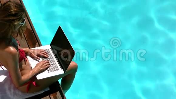迷人的黑发休息和使用笔记本电脑视频的预览图
