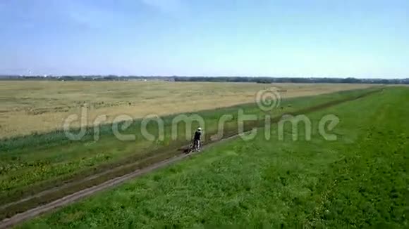 人在农村公路上骑自行车空中景观视频的预览图
