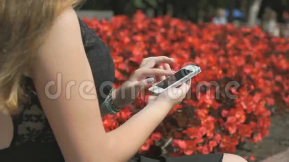在户外公园里拿着智能手机的女孩视频的预览图