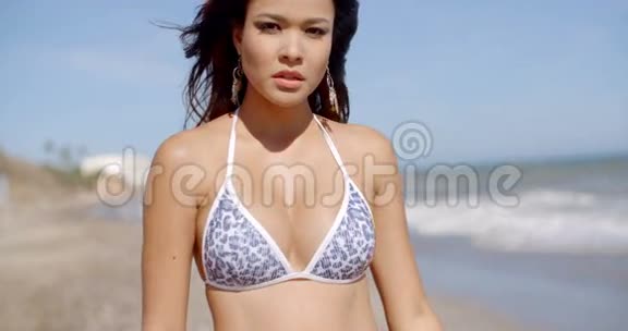 穿着比基尼在海滩上迷人的年轻女子视频的预览图