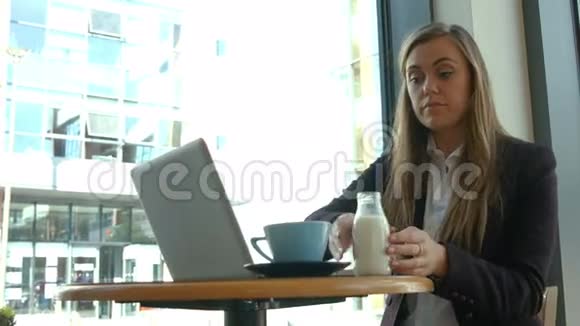 在咖啡馆使用笔记本电脑的女商人视频的预览图