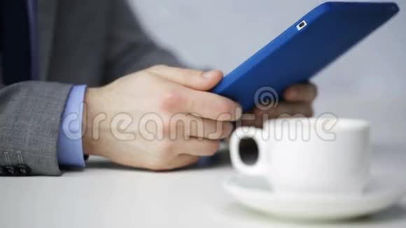 近距离接触平板电脑喝咖啡的男人视频的预览图