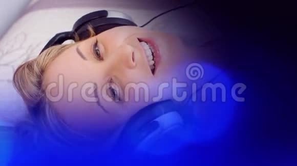 快乐的年轻女子听音乐蓝色背景视频的预览图