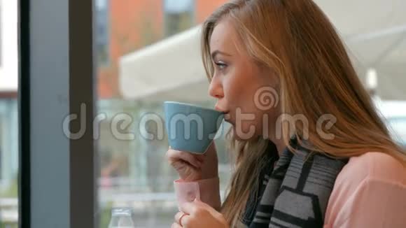 在咖啡馆里喝咖啡的金发美女视频的预览图