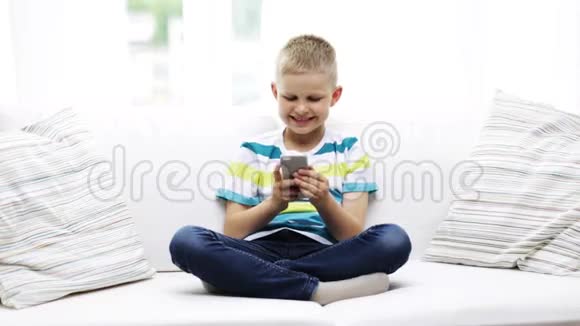 带智能手机的微笑男孩在家视频的预览图
