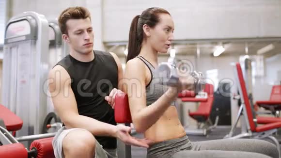 在健身房锻炼哑铃肌肉的年轻夫妇视频的预览图